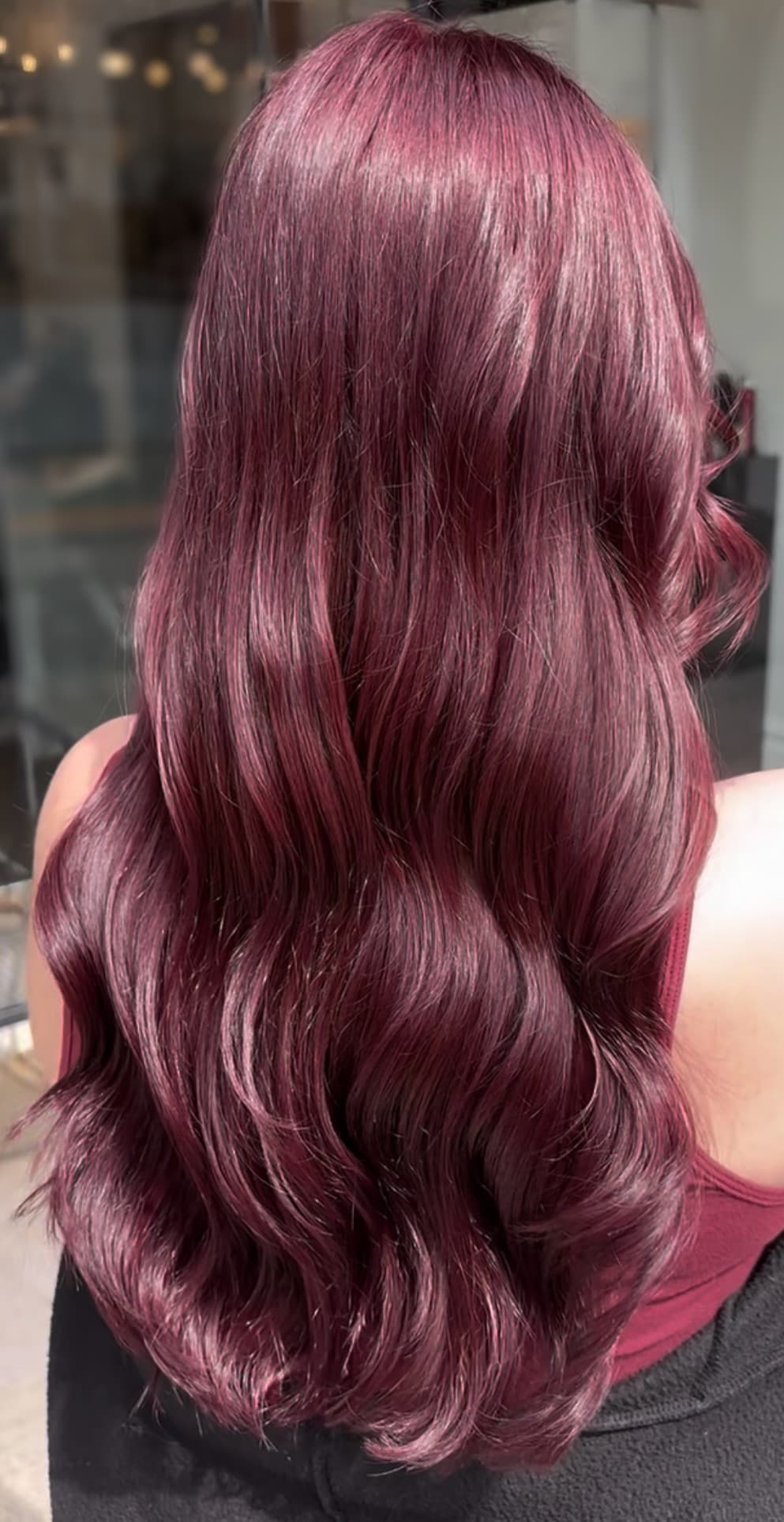 Deep burgundy hair color result, styled in soft waves.
