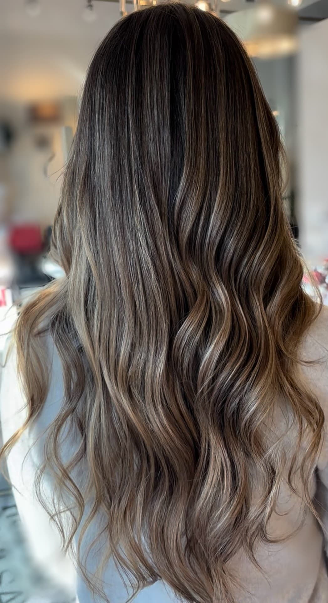 Dimensional brunette balayage result, styled in waves.