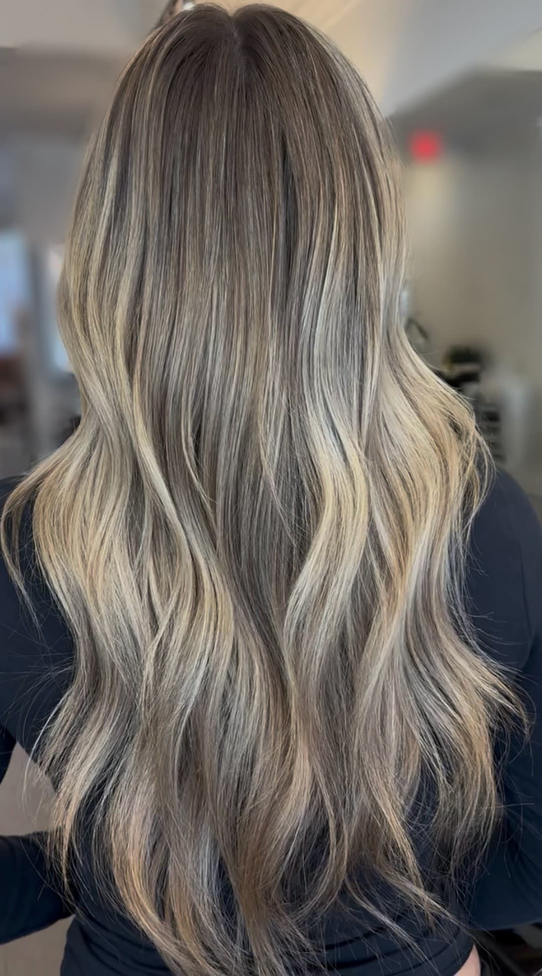 Dimensional blonde balayage result, styled in waves.